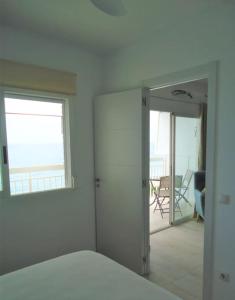 a bedroom with a mirror and a room with a balcony at Siente el mar in Villajoyosa