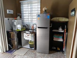 a small kitchen with a refrigerator and a counter at Studio Teratak Alisha Permatang Pauh in Permatang Pauh