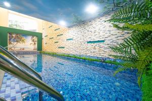 una piscina junto a una pared de ladrillo en Golden Star Hotel by THG, en Da Nang