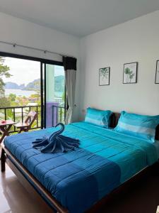 a bedroom with a large bed with a blue blanket at View Garden Resort in Phi Phi Islands