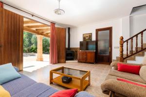 a living room with a couch and a tv at YourHouse Es Pleto Villa in Lloret de Vistalegre