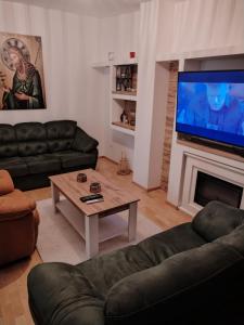 sala de estar con sofá, TV y mesa en Bella Lux Centar, en Mladenovac