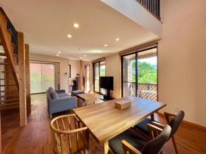 石垣島的住宿－HONRENGA石垣島，客厅配有木桌和椅子