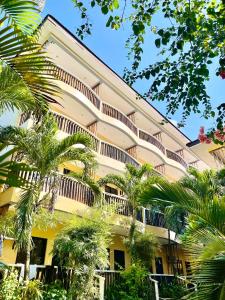 un grand bâtiment avec des palmiers devant lui dans l'établissement Bamboo Beach Resort & Restaurant, à Boracay