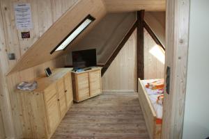 an attic room with a bed and a television at Ferienwohnung Nicklich in Berbisdorf