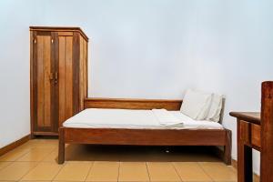 a bed in a room with a wooden cabinet at OYO Life 92589 Geusan Ulun Residence in Bandung