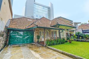 a house with a green garage in a yard at OYO Life 92589 Geusan Ulun Residence in Bandung