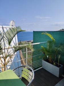 a balcony with a table and chairs and the ocean at Joli studio cocooning & discret, à 2mns de la 4 voies in La Possession