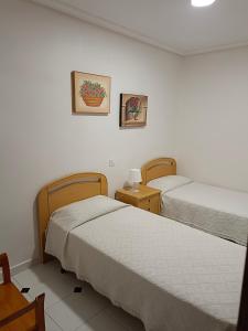 Cette chambre comprend 2 lits et une table. dans l'établissement Просторная квартира рядом с морем в хорошем районе, à Torrevieja