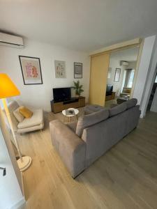 a living room with a gray couch and a television at Apartament Mariola in Calpe