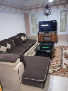 a living room with a couch and a flat screen tv at ANGELA HOME in Douala