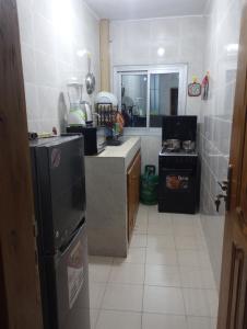 a kitchen with a sink and a refrigerator in it at ANGELA HOME in Douala