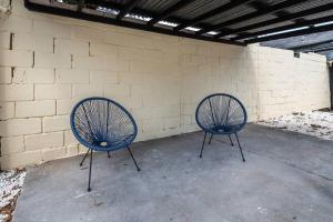 2 chaises bleues assises à côté d'un mur de briques dans l'établissement LE SAINT CLEMENT B AVEC SALLE DE SPORT, à Rouen