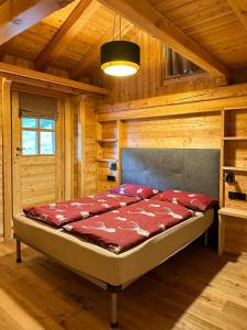 ein Schlafzimmer mit einem Bett in einer Holzhütte in der Unterkunft Maroc Mountain Chalet in Madonna di Campiglio