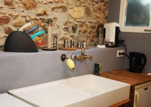 a kitchen counter with a sink and a stone wall at Domaine Ostau Montplaisant in Ponlat-Taillebourg