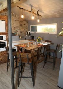 a kitchen with a table and chairs in a room at Domaine Ostau Montplaisant in Ponlat-Taillebourg