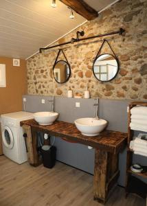 a bathroom with two sinks and a washer and dryer at Domaine Ostau Montplaisant in Ponlat-Taillebourg