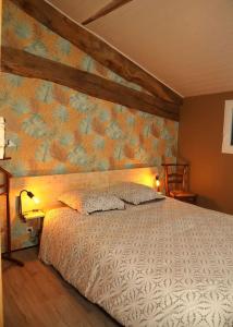 1 dormitorio con 1 cama con pared de flores en Domaine Ostau Montplaisant, en Ponlat-Taillebourg
