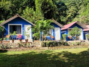 a blue house with chairs in front of it at Pebbles Resort in Rishīkesh