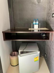 a shelf on top of a small refrigerator at ยูสีเกด รีสอร์ท in Si Sa Ket