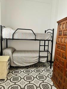 Ce lit superposé se trouve dans un dortoir doté d'un sol. dans l'établissement ALOJAMIENTO RURAL AN CA LA ABUELA PILAR, à El Real de la Jara