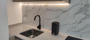 a kitchen with a sink and a marble counter top at Precioso apartamento de diseño para 4-6 personas VT-55212-V in Valencia