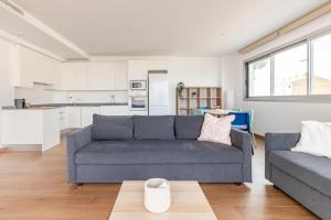 ein Wohnzimmer mit einem Sofa und einer Küche in der Unterkunft Orilla del mar in Oliva