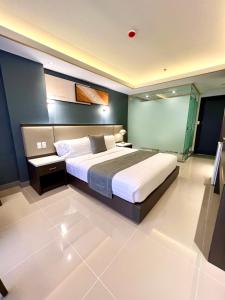 um quarto com uma cama grande num quarto em Subic Riviera Hotel & Residences em Kababae