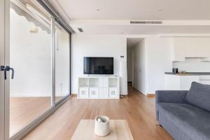 ein Wohnzimmer mit einem Sofa und einem TV in der Unterkunft Orilla del mar in Oliva