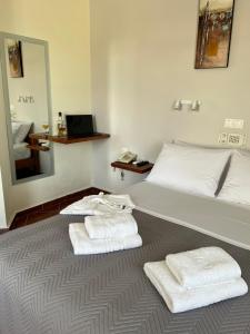 a bedroom with a bed with towels on the floor at Iolkos Hotel Apartments in Kato Daratso