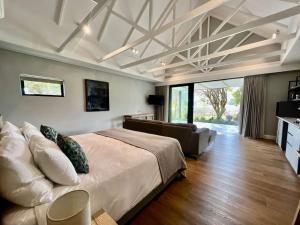 a bedroom with a large bed and a living room at Lynx Wine Estate in Franschhoek