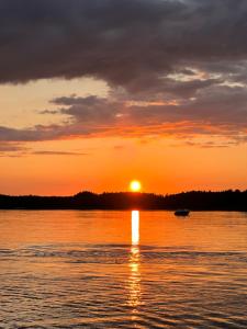 a sunset over a body of water with a boat at Dom przy molo in Augustów