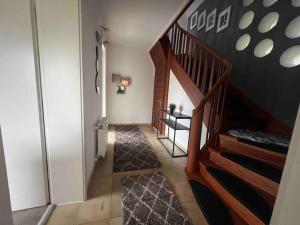 a hallway with a wooden staircase with a stair case at Villa Höpen 125qm 4 Schlafzimmer Citynah 5 Zi. Parkplatz Terasse WIFI in Seevetal