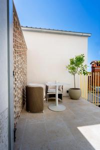 a patio with a table and a tree on a balcony at Spirito Santo Palazzo Storico in Rovinj