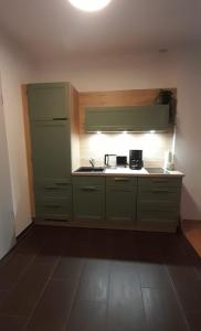 a kitchen with green cabinets and a stove top oven at Suite - Mein Ankerplatz in Stralsund