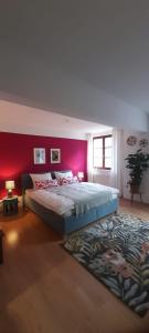 a bedroom with a large bed with a red wall at Suite - Mein Ankerplatz in Stralsund