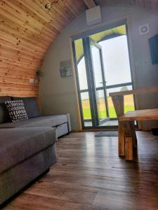 a living room with a couch and a table at Eastfield Glamping Farm in Spennithorne