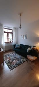 a living room with a green couch and a rug at Suite - Mein Ankerplatz in Stralsund