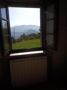 a window in a room with a view of a field at Affittacamere Roggio , Vagli di Sotto , Lucca in Fabbrica