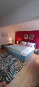 a bedroom with a large bed with a red wall at Suite - Mein Ankerplatz in Stralsund