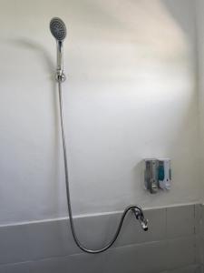 a shower with a shower head in a bathroom at D'Flora Homestay in Labuan Bajo