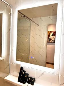 a mirror above a sink in a bathroom at Subic Riviera Hotel & Residences in Kababae