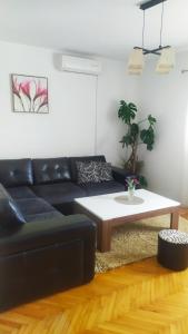 Sala de estar con sofá negro y mesa de centro en Kuća Moric en Tivat