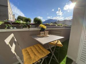 d'une petite table et de deux chaises sur un balcon. dans l'établissement Le Bourget, Grand appartement proche du centre, à Grenoble
