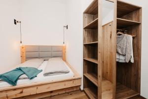 a bed in a room with wooden shelves at Ferienappartement Bergliebe in Grossarl