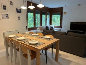 Una mesa de comedor con sillas y un sofá. en Tuca - Piso de 3 habitaciones en Betren-Vielha con garaje, en Vielha