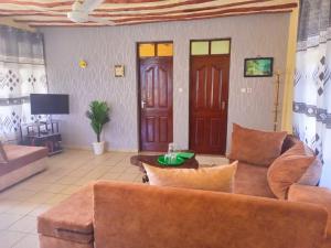 ein Wohnzimmer mit einem Sofa und einem Tisch in der Unterkunft Simba Apartments in Diani Beach