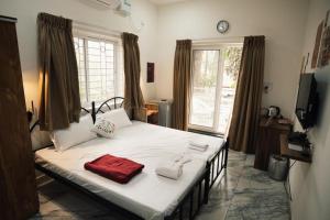 a bedroom with a large bed with towels on it at Nirvana Homestays in Siolim