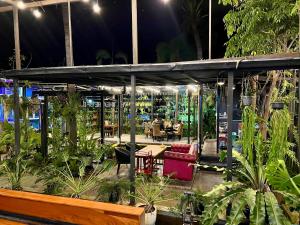 四色菊的住宿－ยูสีเกด รีสอร์ท，种植了植物的温室,桌子和椅子
