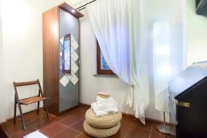 a room with a chair and a window and a table at Borgo Caere in Ladispoli